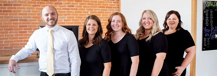 Chiropractor Clear Lake WI Chase O'Keefe With Team At Front Desk Chiropractor Clear Lake WI Chase O'Keefe With Team At Front Desk